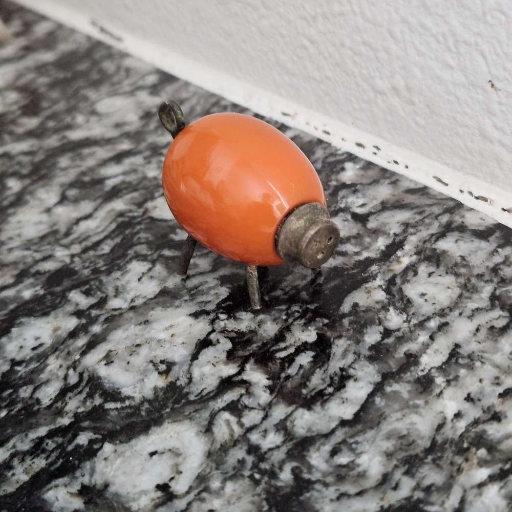 antique orange piggy shaped salt shaker with metal legs and nose/spout